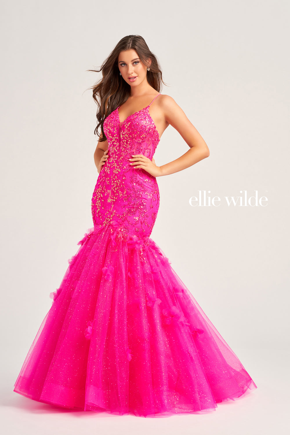 Have all eyes on you when you walk into your senior prom rocking this glamorous Ellie Wilde gown style EW35080. Featuring a plunging v cut neckline with two spaghetti straps that create an adjustable lace up corset back, perfect to cinch your waist and show off your curves. Mermaid silhouette is adorned in a beautiful floral appliques.