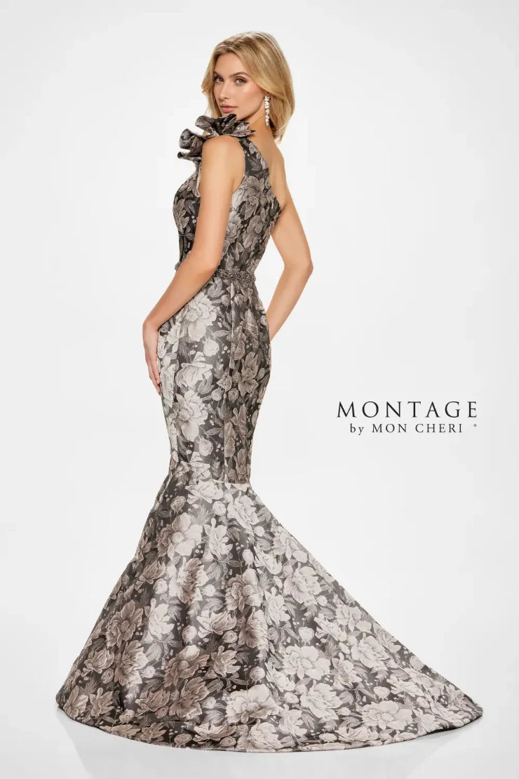 Turn heads in this striking trumpet. Its fitted bodice accentuates the waist, while the flared skirt gracefully cascades from the knees, creating that classic trumpet silhouette known for its flattering effect. The dramatic floral brocade adds depth and dimension, while the assymmetrical shoulder design with dreamy tulle and ruffle detail adds an extra touch of glamour. Remove the matching wrap for a sleek and sophisticated look that allows the intricate details of the gown to truly shine.