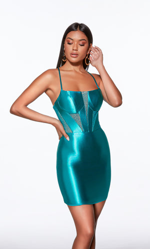 Woman wearing a teal metallic dress with a white background