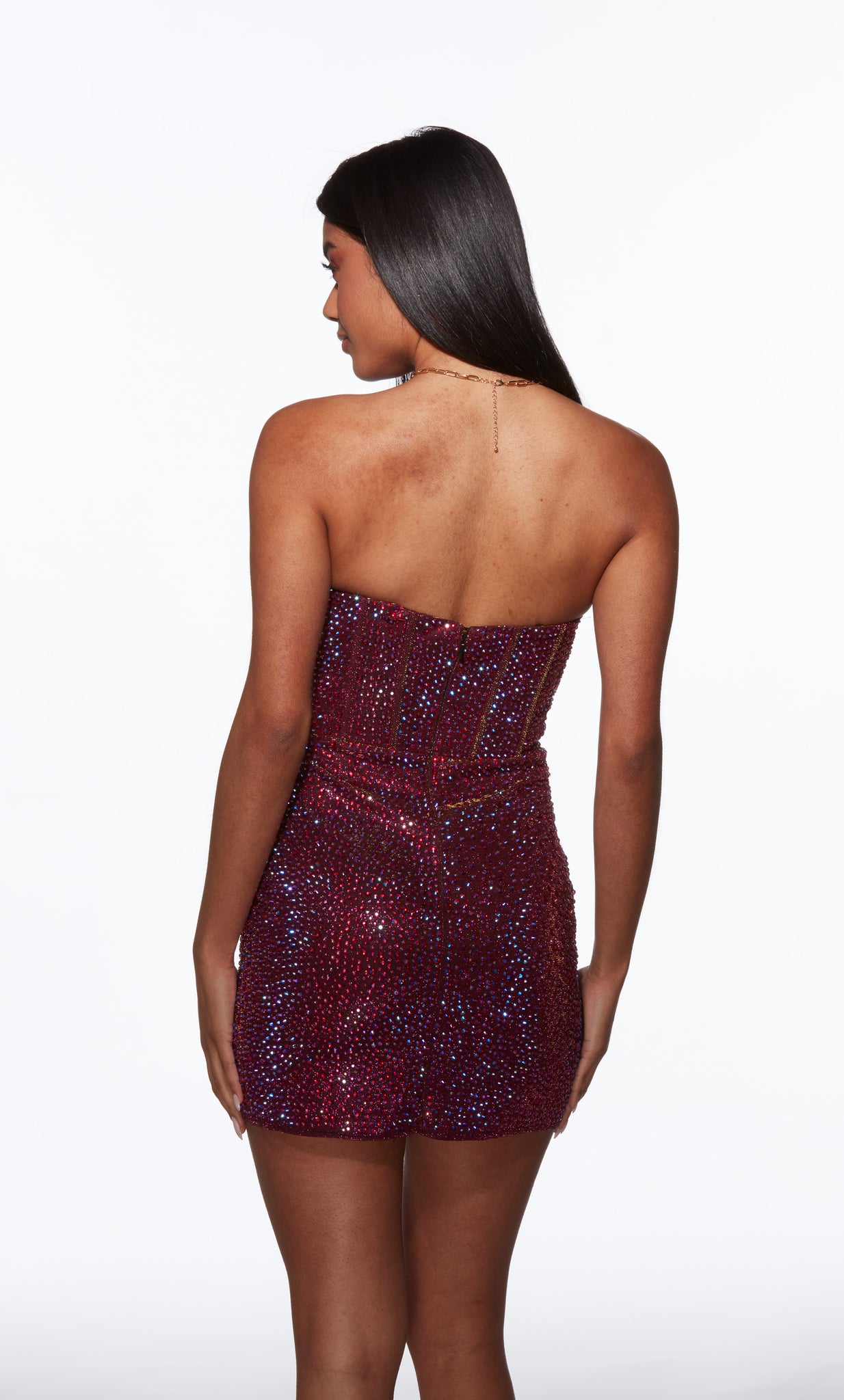 Woman wearing a strapless, sequined burgundy dress on a white background