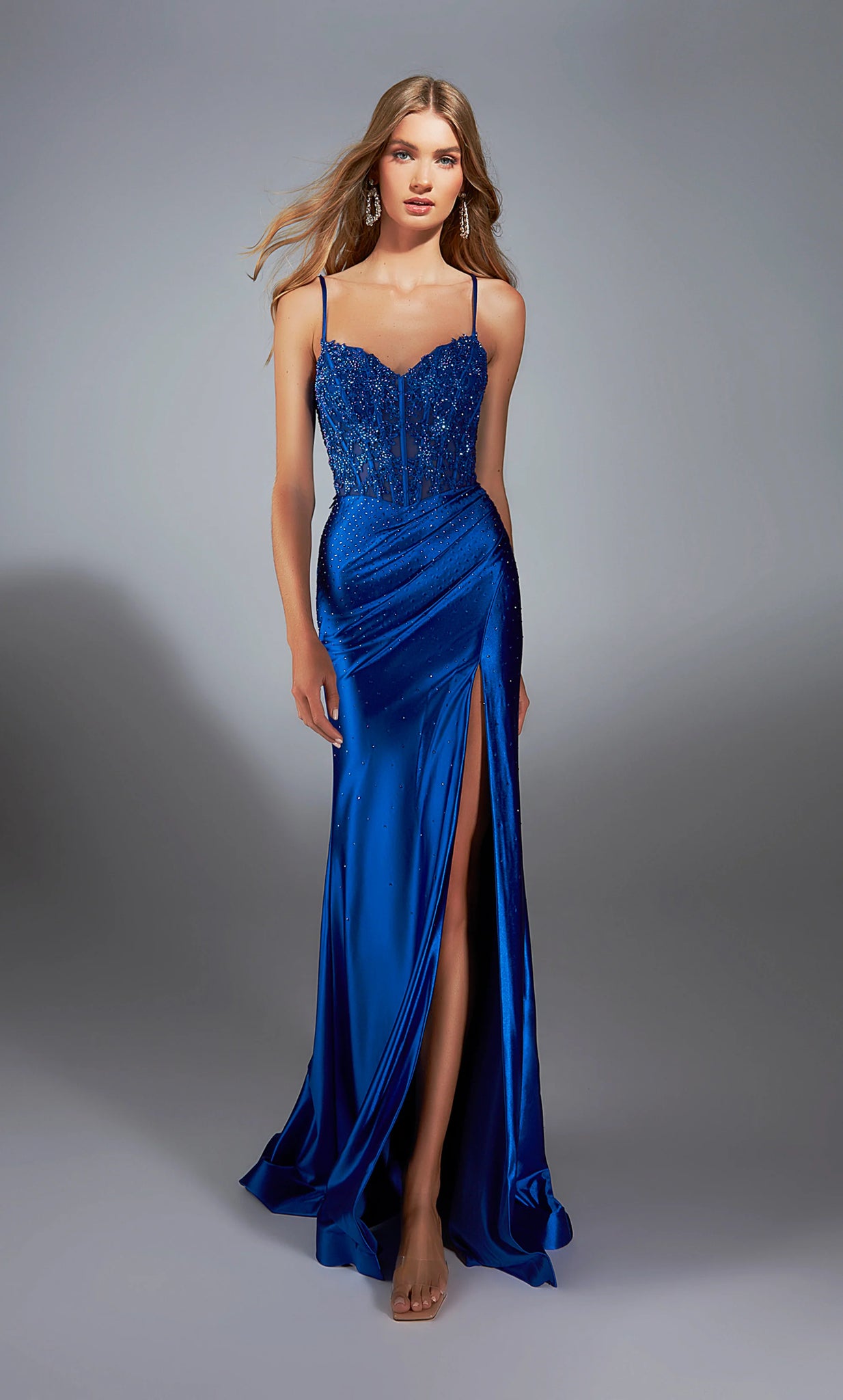 The statement dress of the season style 61827 by&nbsp;Alyce&nbsp;will have everyone doing a double take. The sweetheart neckline is combined with a a corset lace up back embellished with lace applique and adorned beautifully in meticulously placed glistening hot stones that sparsely cascaded down the fitted satin skirt for the perfect amount of illumination to your photos.