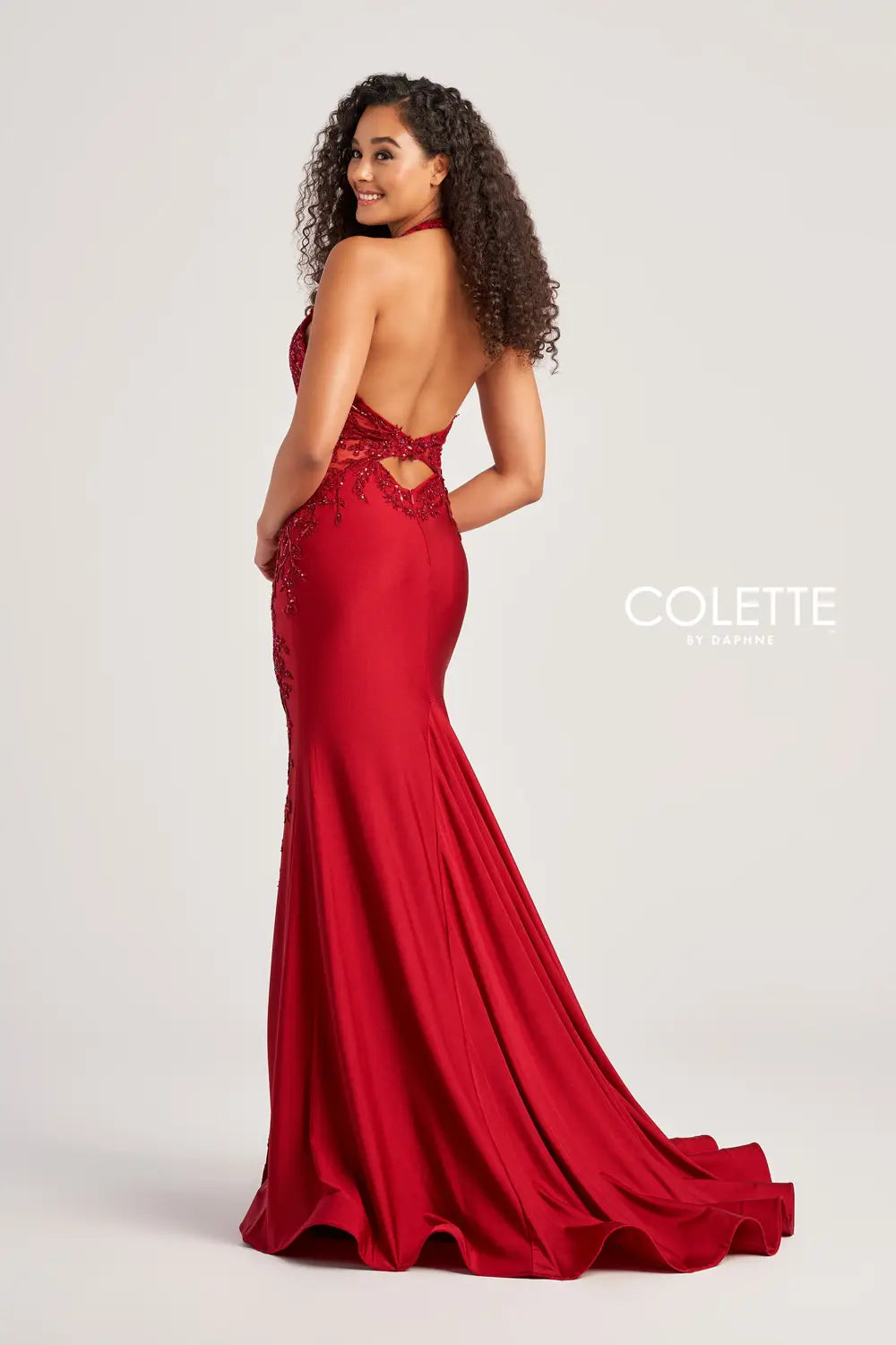 Look sizzling hot at prom in this haute Colette fitted dress style CL5206 made in curve hugging stretch jersey material adorned with beaded lace appliques sequins and sparkling heat set stones. This phenomenal style features a halter strap bodice with deep V neckline and low back with a zipper closure and cut out. The long slim skirt has a sexy high front side slit and sweep train.