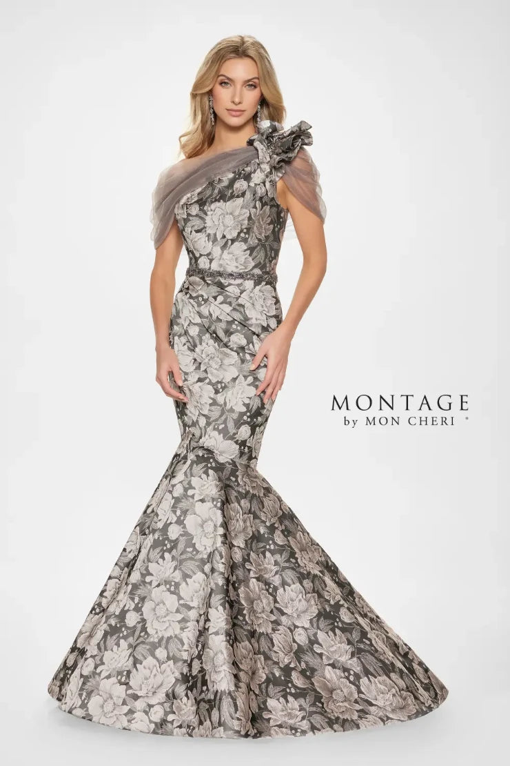 Turn heads in this striking trumpet. Its fitted bodice accentuates the waist, while the flared skirt gracefully cascades from the knees, creating that classic trumpet silhouette known for its flattering effect. The dramatic floral brocade adds depth and dimension, while the assymmetrical shoulder design with dreamy tulle and ruffle detail adds an extra touch of glamour. Remove the matching wrap for a sleek and sophisticated look that allows the intricate details of the gown to truly shine.