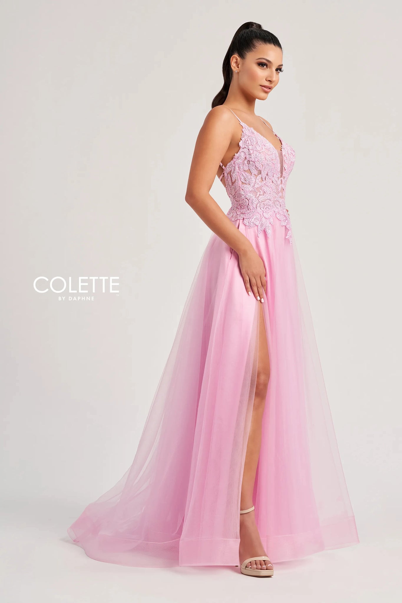 Feel like a star in this glamorous long dress by Colette, style CL8100. This lovely A line dress features a V neckline with thing straps, and a striking corset bodice adorned with beadwork, lace detailing, and sexy open lace up back that gives you an enhanced figure. The light tulle skirt has a thigh high slit, a gorgeous train, and side pockets that add a chic extra touch.