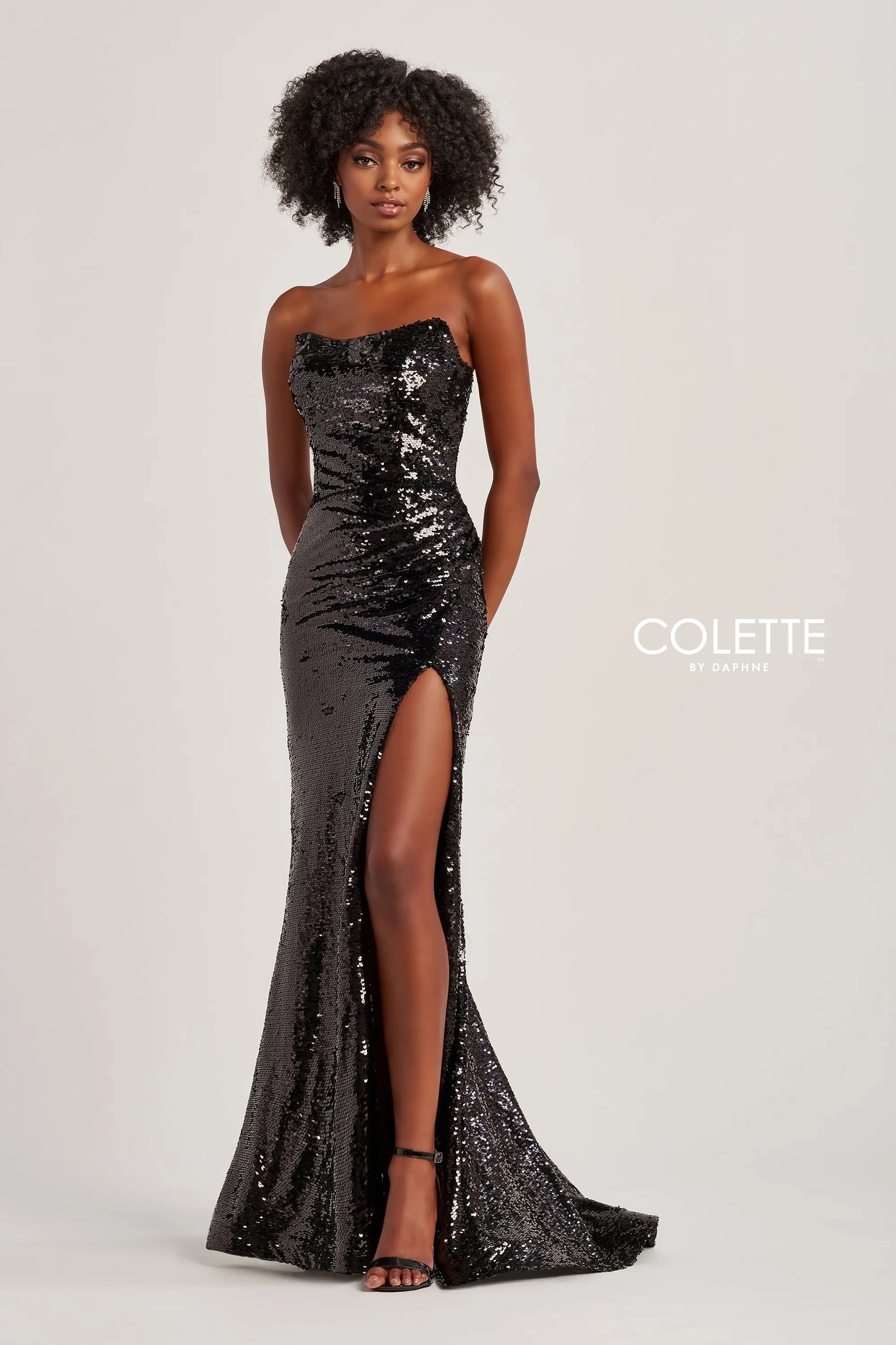 Shimmer and shine all night long in this liquid stretch sequin Colette prom dress style CL8300. This glimmering gown showcases a strapless corset bodice with a scoop neckline and low lace up tie back. If you want you can add spaghetti straps which are included. The long slim skirt is covered in sparling sequins with an edgy high front side slit and small back train.