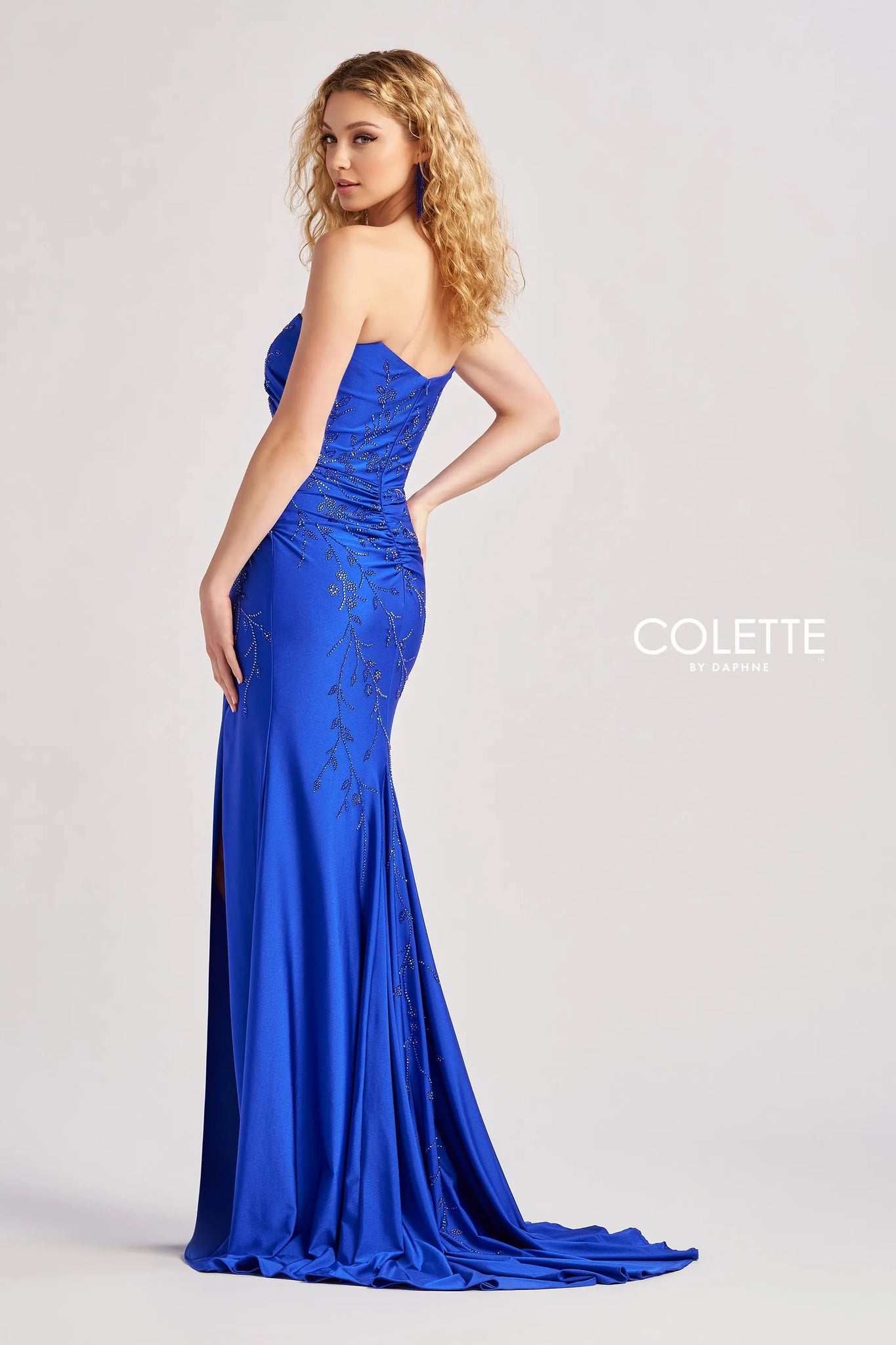 Feel like you just step foot off the red carpet in this gorgeous long dress by Colette, style CL8500. Showcasing a fitted silhouette with a strapless scoop neckline. This number is made out of jersey material that hugs the curves gorgeously. This number is adorned with glistening beadwork that cascades down the dress. A thigh high slit is the perfect final touch.