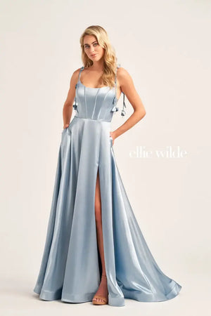 Turn heads when walking into prom with this long class dress by Ellie Wilde, style EW35215. This dress has a scoop neckline, a formal corset, graceful satin material, and a slit all in one. On top of everything, this dress comes with pockets that will ensure you to feel both comfortable and glamorous.