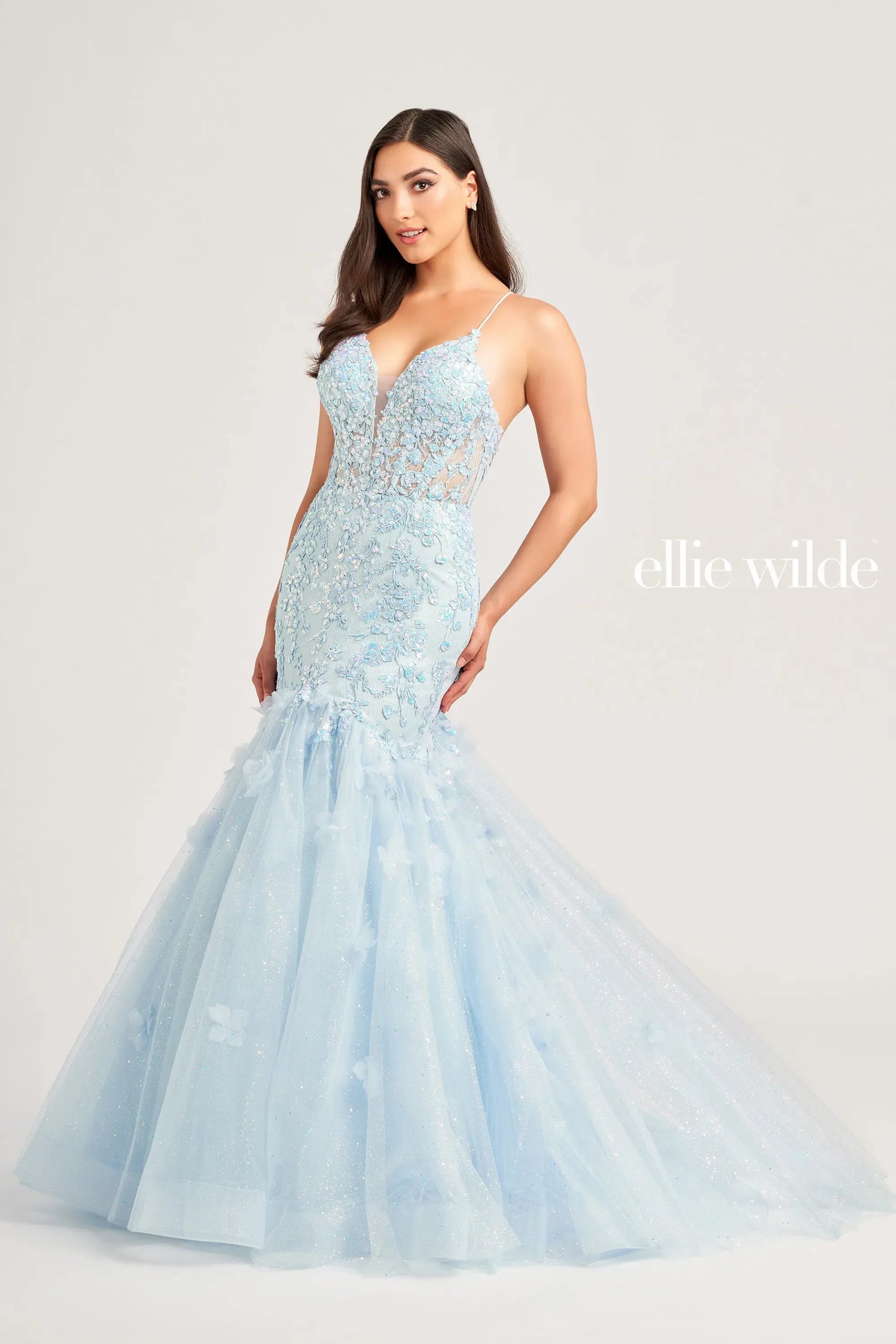 Have all eyes on you when you walk into your senior prom rocking this glamorous Ellie Wilde gown style EW35080. Featuring a plunging v cut neckline with two spaghetti straps that create an adjustable lace up corset back, perfect to cinch your waist and show off your curves. Mermaid silhouette is adorned in a beautiful floral appliques.