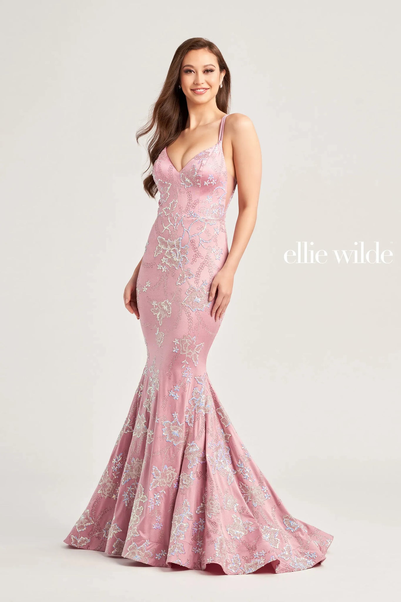 Unique and classy gown by Ellie Wilde EW35083 is the perfect choice for your senior prom. An adjustable lace up corset is perfect to cinch your waistline and show off your curves. Fitted silhouette is adorned in a ravishing subtle floral pattern. A long sweep train and v cut neckline are added to complete the look.