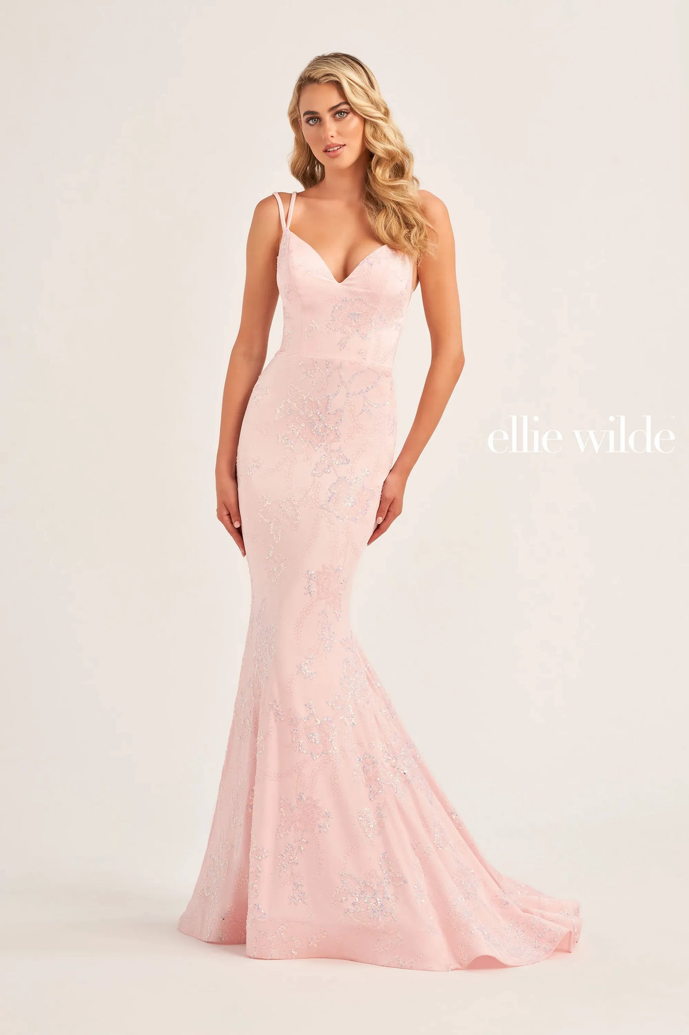 Unique and classy gown by Ellie Wilde EW35083 is the perfect choice for your senior prom. An adjustable lace up corset is perfect to cinch your waistline and show off your curves. Fitted silhouette is adorned in a ravishing subtle floral pattern. A long sweep train and v cut neckline are added to complete the look.