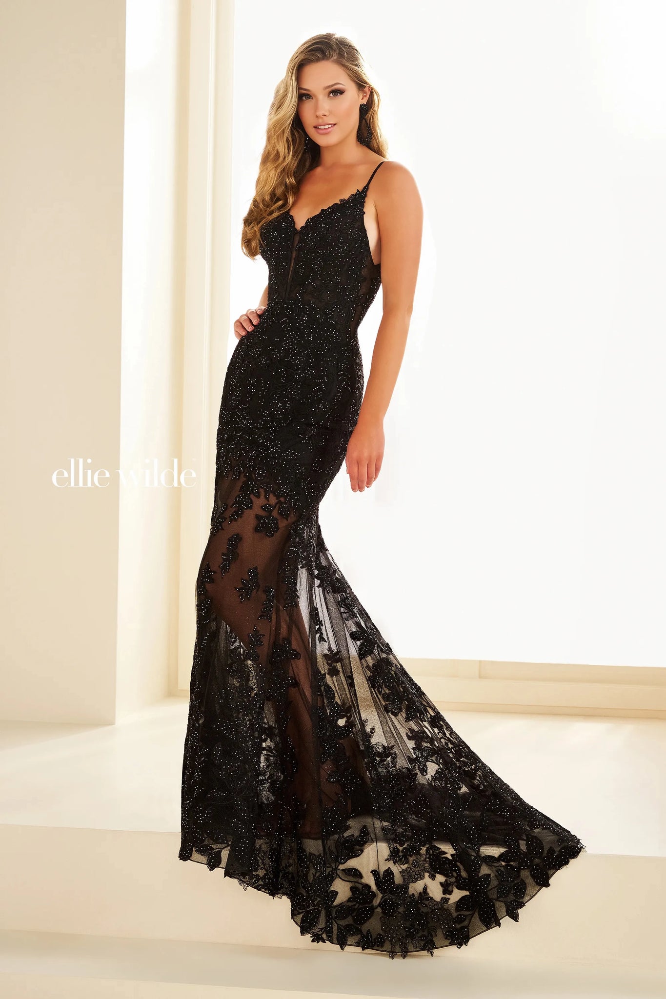 Showcasing the sophisticated long style EW36014 by Ellie Wilde. The illusion bodice is embellished with delicate lace applique that cascades down the trumpet skirt and scallops along the bottom of the fly away train. Headlining the detachable skirt liner to give you more than one look for your eventful evening.