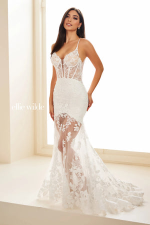 Showcasing the sophisticated long style EW36014 by Ellie Wilde. The illusion bodice is embellished with delicate lace applique that cascades down the trumpet skirt and scallops along the bottom of the fly away train. Headlining the detachable skirt liner to give you more than one look for your eventful evening.