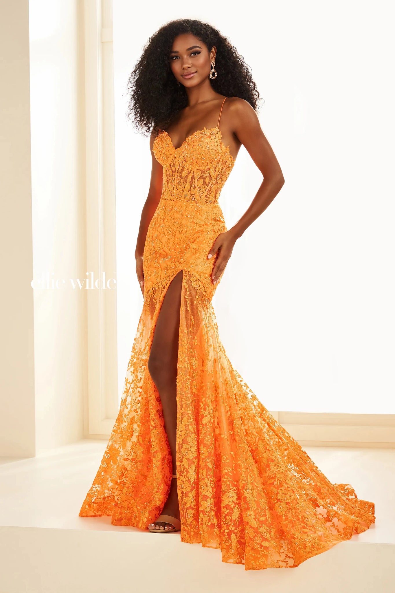 Stay classy when wearing this long fitted dress by Ellie Wilde, style EW36016. Showcasing a modern v- neckline with thin straps leading to a back zipper closure. The see through silhouette of this ensemble will for sure going to hug your body gorgeously. Fully embellished with floral embroidery applique and glistening beadwork. The bottom of this dress has lace and glitter tulle. For the perfect final touch t has a sexy high thigh slit and a classy train.