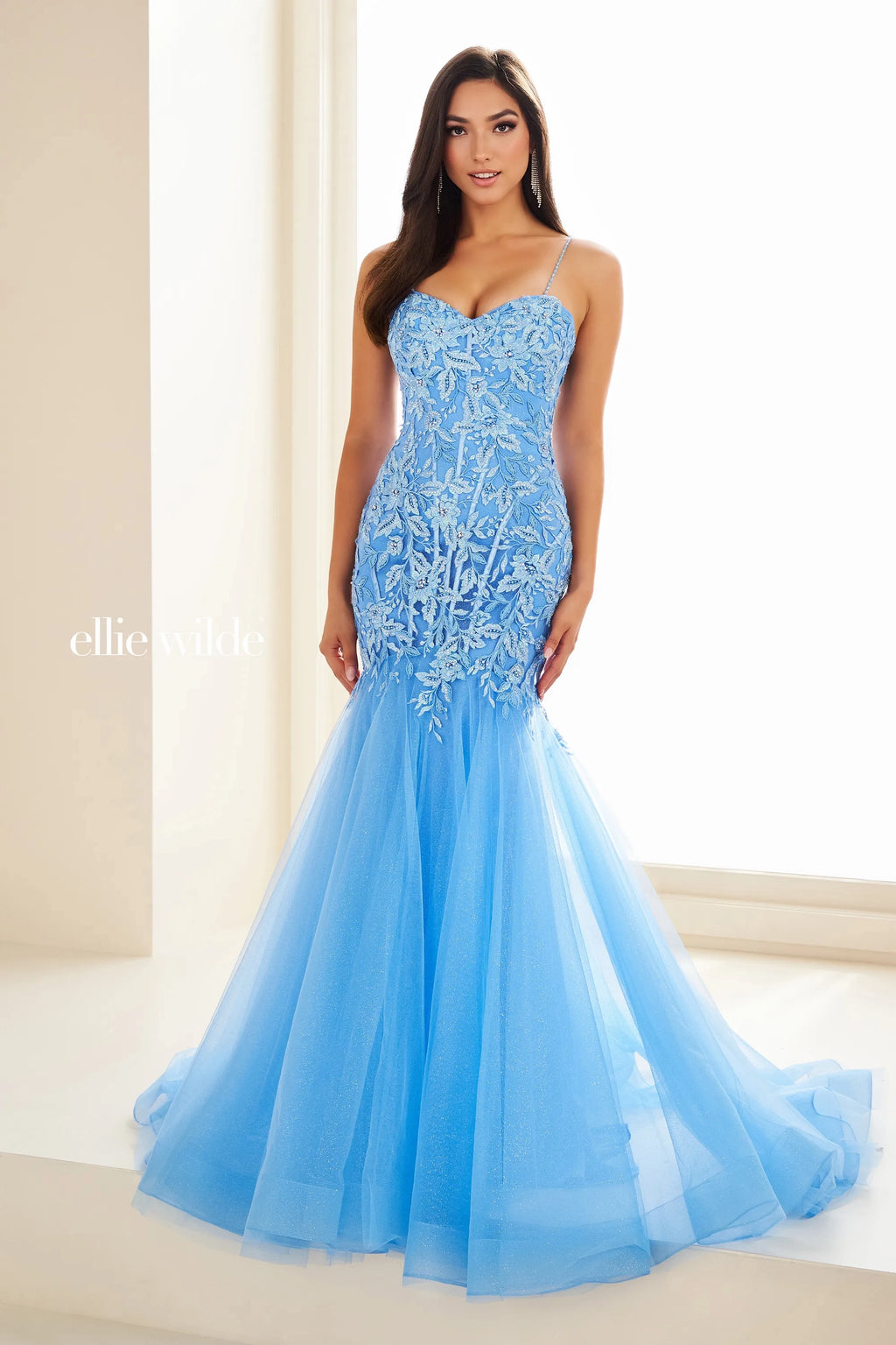 Have jaws on the floor when you make an entrance with this stunning dress by Ellie Wilde, style EW36060. The mermaid dress displays a sweetheart neckline supported with two dainty straps that lead to a corset lace up back. The bodice of this dress features an array of patterns displaying appliques and beading. The mermaid skirt and train is a change of scenery with glitter tulle, giving this dress a contrast of designs.