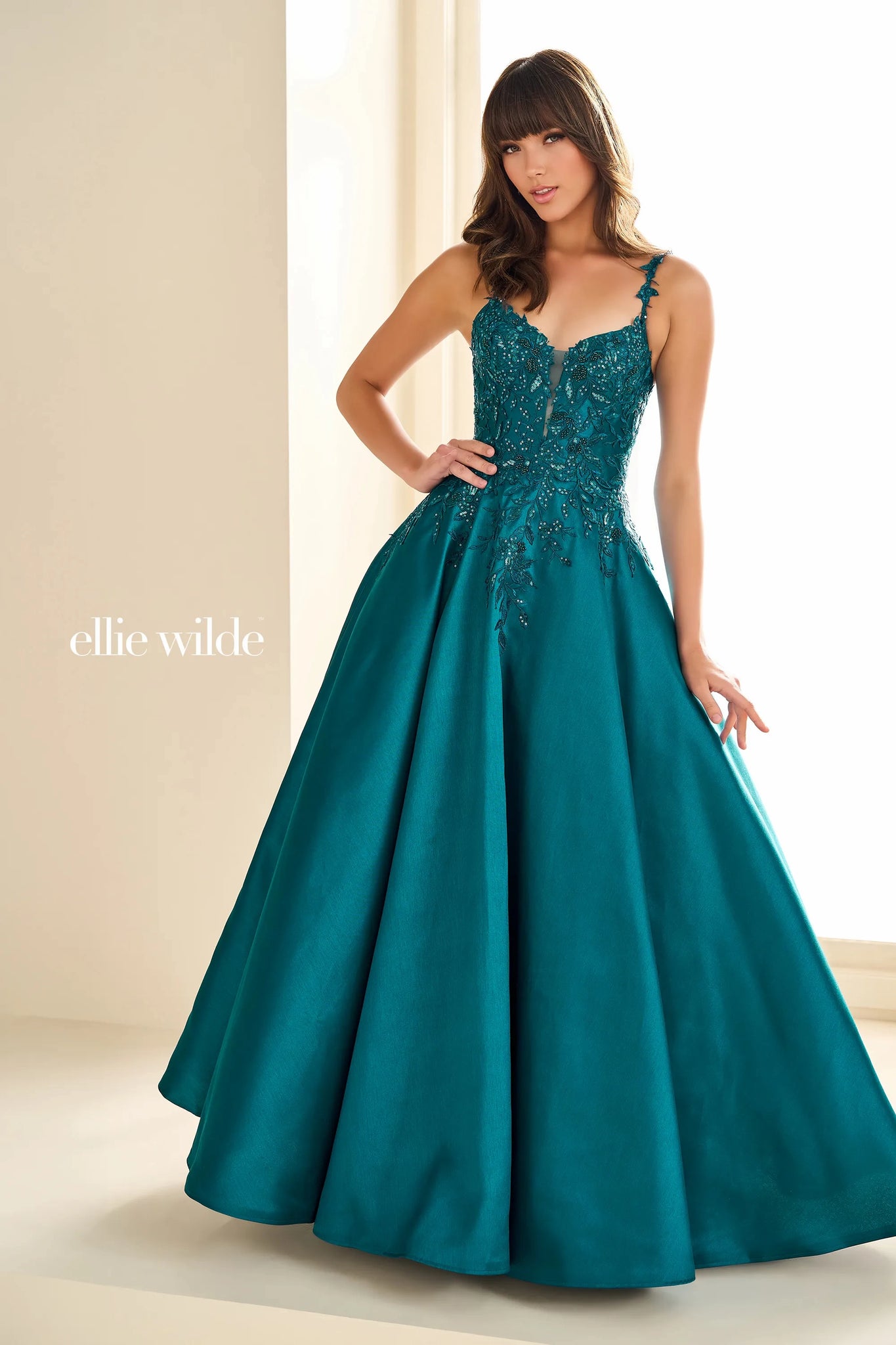 Have a memorable night in Ellie Wilde style EW36094 at your special event. This lovely A line dress showcases a modest v neckline with dainty floral shoulder straps. The fitted bodice is decorated with unique floral applique flowing into the full satin skirt ensuring you look and feel beautiful.