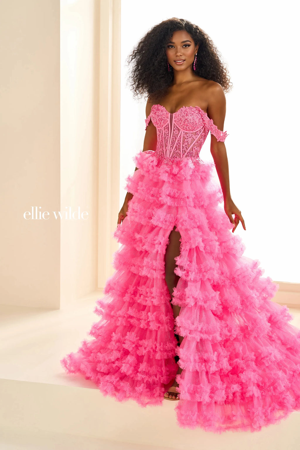 Show off your inner fashionista in this gorgeous A line dress from Ellie Wilde style EW36201. The corset structured bodice is made of sheer illusion with flower appliques adoring it. The ruffled layered aline skirt has a front thigh high side lit and a sweeping train. Included our separate straps to add to the strapless look.