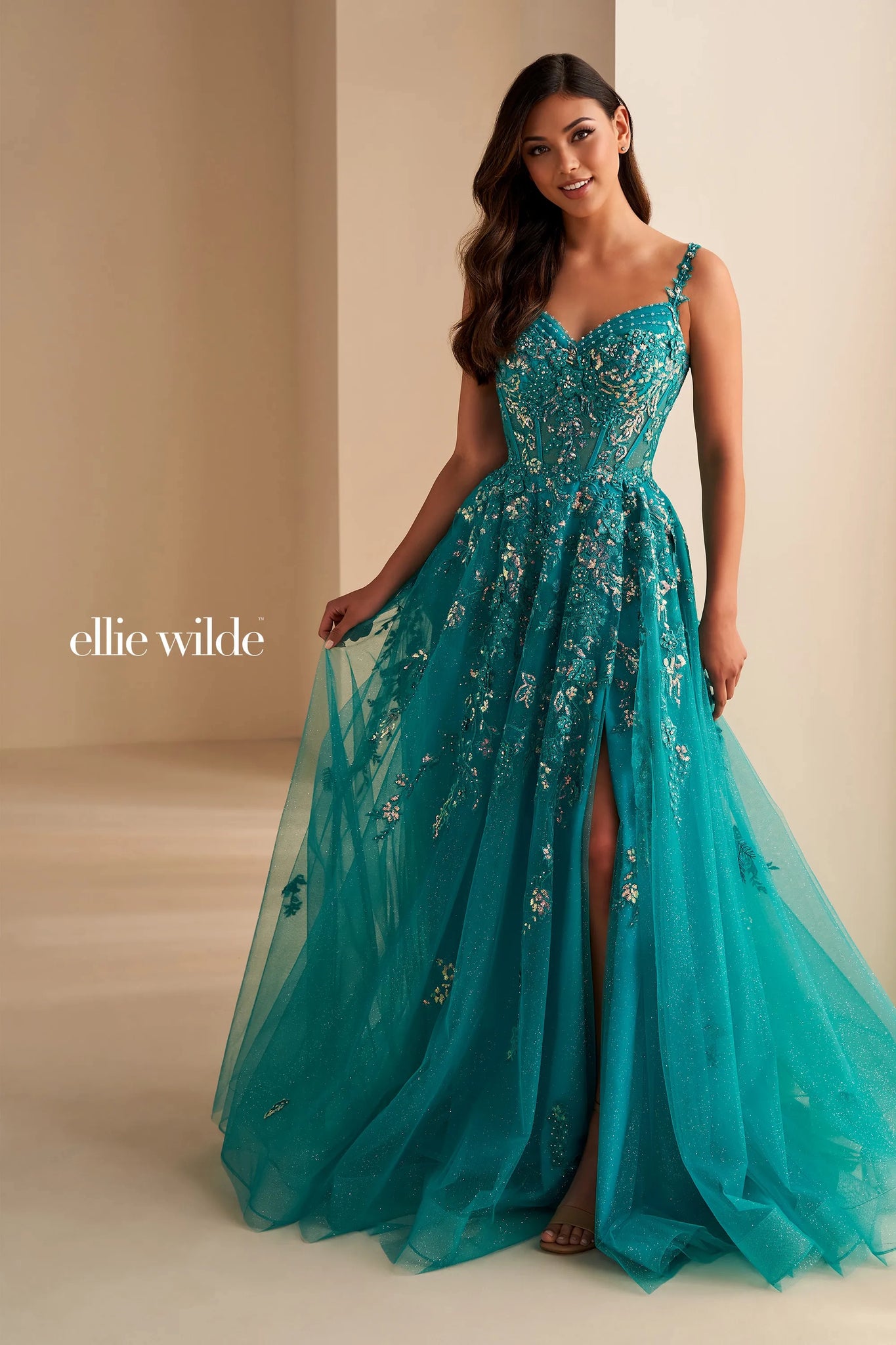 Live a real life fairy tale at this years prom wearing this princess worthy Ellie Wilde long dress style EW32604 made in regal shades of tulle fabric. This impeccable gown showcases an illusion corset bodice adorned with lace appliques and beads with thin straps that can be worn on or off the shoulder and a zipper closure back. The a line long skirt has both glitter tulle and tulle layers with a front side slit and side pockets.