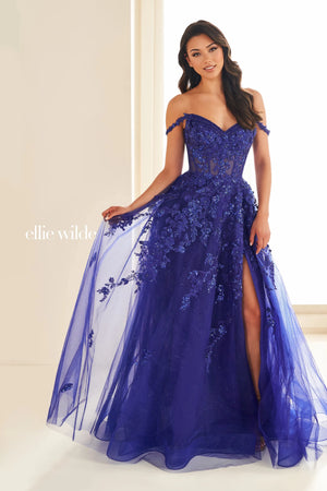 Live a real life fairy tale at this years prom wearing this princess worthy Ellie Wilde long dress style EW32604 made in regal shades of tulle fabric. This impeccable gown showcases an illusion corset bodice adorned with lace appliques and beads with thin straps that can be worn on or off the shoulder and a zipper closure back. The a line long skirt has both glitter tulle and tulle layers with a front side slit and side pockets.
