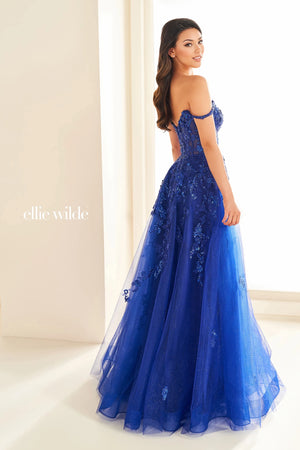 Live a real life fairy tale at this years prom wearing this princess worthy Ellie Wilde long dress style EW32604 made in regal shades of tulle fabric. This impeccable gown showcases an illusion corset bodice adorned with lace appliques and beads with thin straps that can be worn on or off the shoulder and a zipper closure back. The a line long skirt has both glitter tulle and tulle layers with a front side slit and side pockets.