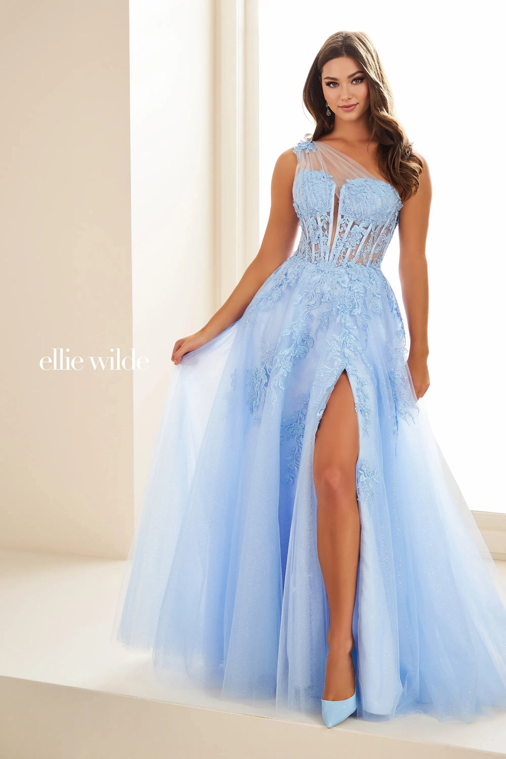 Feel like a princess wearing this gorgeous Ellie Wilde dress, style EW36203. This stunning A line dress features a stylish V neckline complement by thin straps that leads to a corset lace up back. Made from glitter tulle material, this dress is adorned with glistening glitter and dazzling beading.