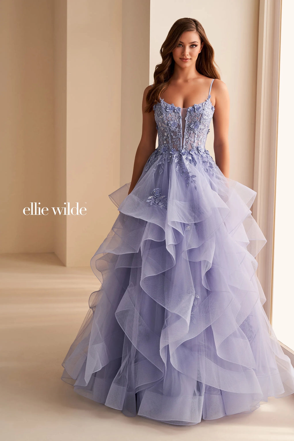 Have all eyes in you when making your grand entrance in your next event wearing this outstanding long A-line dress from Ellie Wilde style EW36225. Showcasing a plunging scoop neckline with mesh and thin matching straps. It has a lace up back corset bodice that is adorned by ravishing beads, sequins and lace applique. Adding the attention to you is he ruffled multilayered tulle skirt.