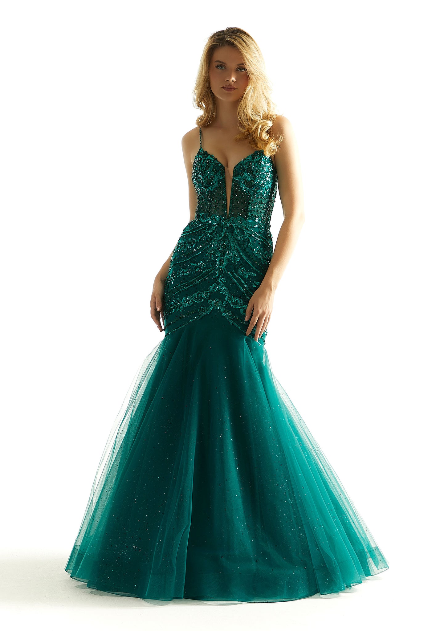Feel classy and elegant in this magnificent long dress by Morilee, style 49014. Showcasing a mermaid silhouette with plunging v neckline that has mesh for q modest touch. This ensemble is adorned with glistening sequins and dazzling beadwork. The corset bodice is sure to hug your body gorgeously. The tulle skirt has glitter for a touch of sparkle.