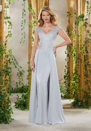 MGNY By Mori Lee 71906. This long dress graces a plunging scalloped V-neckline with cap sleeves. The fitted bodice is designed with embroidery and is styled with a back zipper. The full length skirt is complemented with an overskirt and a train finish ONLY 1 IN STOCK  STYLE IS DISCONTINUED 