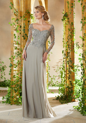 Long sleeve evening gown featuring a beaded and embroidered bodice. A stretch mesh skirt with beaded waistband completes the look.  Sizes: 2-24  Available in Eggplant, Pewter  If we do not have your desired size or color in stock please call or email us for availability!
