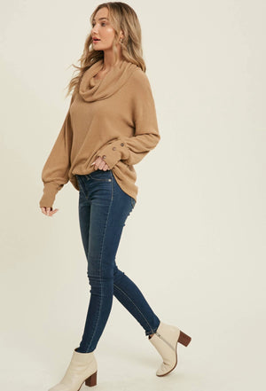 Soft rib knit top with a loose draped cowl neck, drooped shoulder, long puff sleeves, and button detail on wrists. 