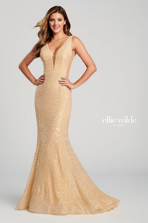 Sleeveless novelty sequin stretch fit and flare gown with a plunging V-neck, sheer insets on the sides, natural waist, open back, horsehair hem and a sweep train.  Sizes: 00-16  Available in Light Pink, Light Gold, Red  If we do not have your desired size or color in stock please call or email us for availability