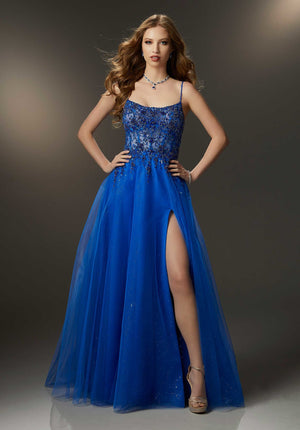Gorgeous prom dress features a sheer embroidered bodice encrusted in rhinestone and crystal beading that meets a delicate glitter tulle skirt that floats off the body. A soft scoop neckline, delicately beaded straps, and a sultry skirt slit finish off the gown.