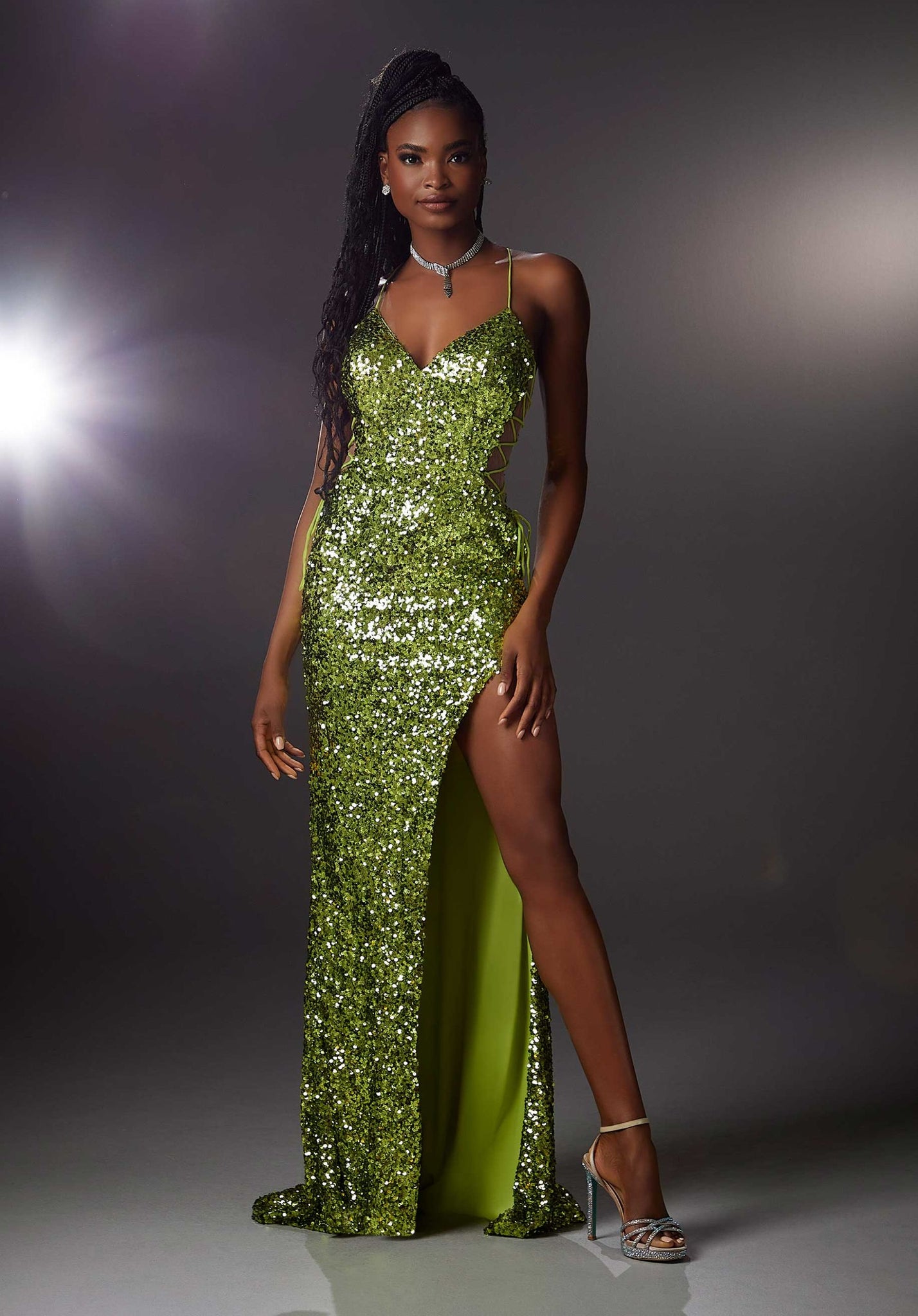 Sparkling allover sequin prom dress is both chic and edgy with illusion lace-up sides, a deep-v neckline, and spaghetti straps that crisscross in the back.